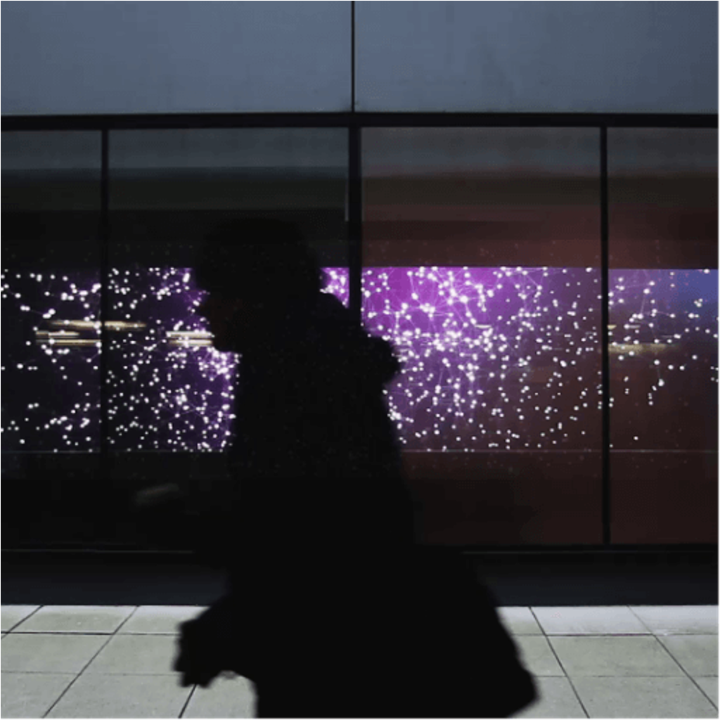 A person walking past the video wall at Imperial College London